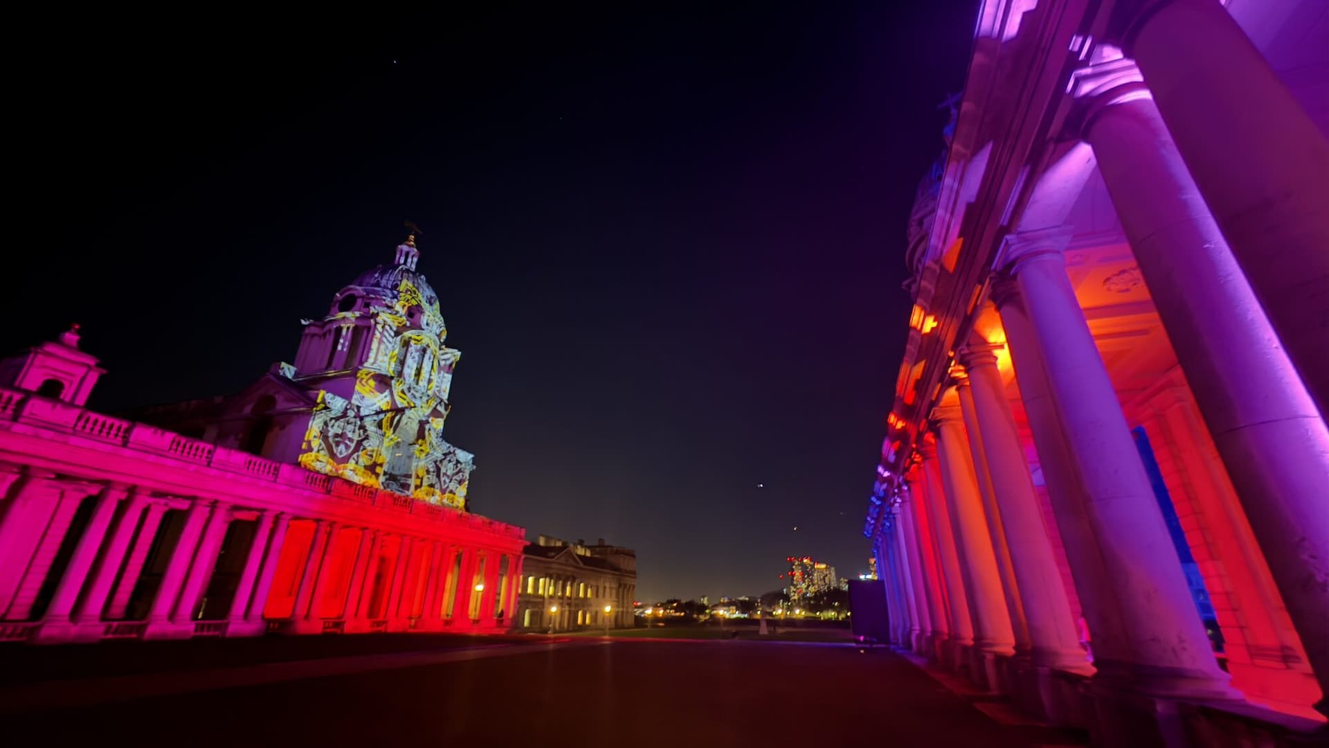 Formes lumineuses abstraites rappelant constellations et structures cosmiques à la surface du bâtiment